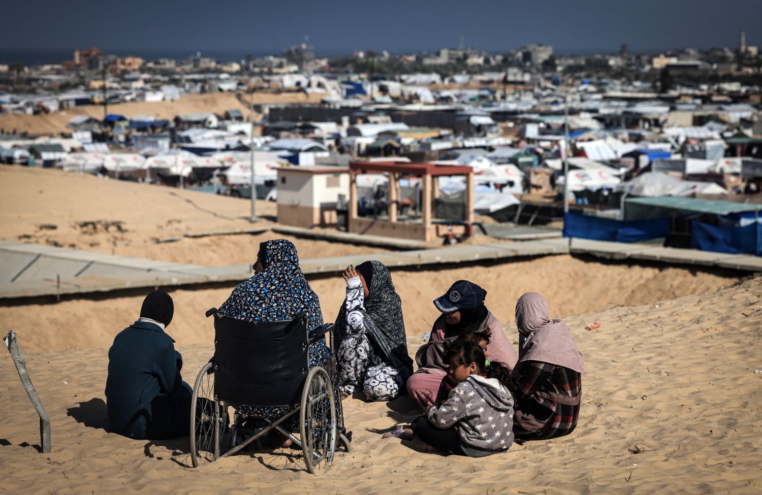 نازحات يتجمعن قرب مخيم مؤقت غرب رفح جنوب قطاع غزة (تصوير أ ف ب)